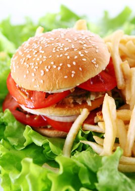 Salata yapraklarında ateş olan büyük ve lezzetli bir hamburger.