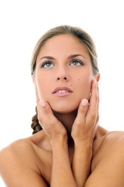 Örgü örmüş güzel bir kızın portresi. Kendine dokunuyor ve beyaz bir arka planda poz veriyor.