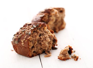 Beyaz ahşap masalarda tahıllı ev yapımı çıtır bir ekmek.