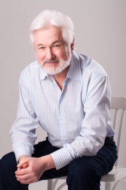Geçmişi gri sakallı yakışıklı yaşlı bir adam.