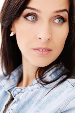 Beyaz bir arka plan üzerinde poz güzel bir esmer kot ceketli portresi