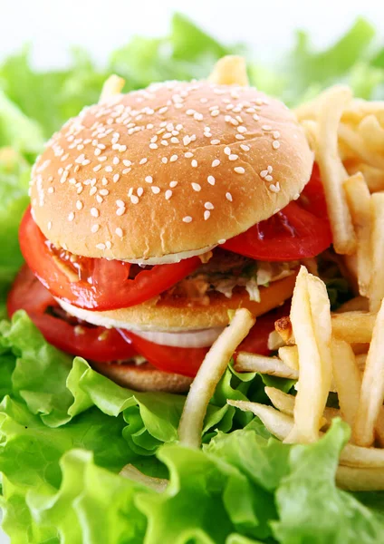 Salata yapraklarında ateş olan büyük ve lezzetli bir hamburger.