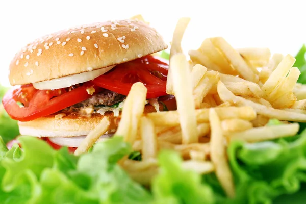 Salata yapraklarında ateş olan büyük ve lezzetli bir hamburger.