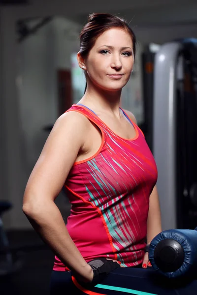 Güzel bir kadın spor salonunda sıkı çalışıyor.