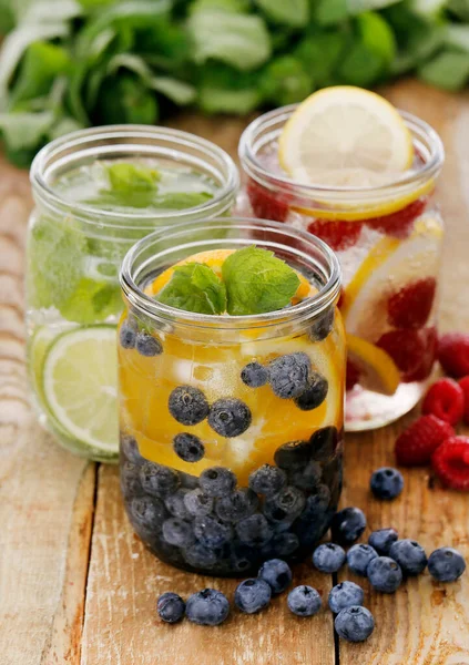 Tahta bir masada pipetle üç farklı soğuk içecek.