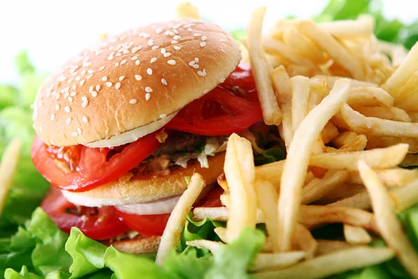 Salata yapraklarında ateş olan büyük ve lezzetli bir hamburger.