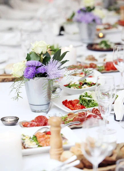 お祝いに花やさまざまな種類の食べ物の大きなダイニングテーブル — ストック写真