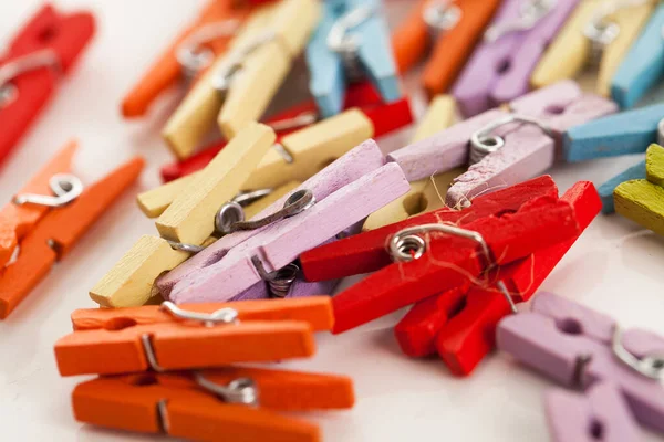 Beyaz bir masanın üzerindeki küçük renkli ofis mandallarının yakın plan resmi.