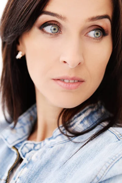 Beyaz bir arka plan üzerinde poz güzel bir esmer kot ceketli portresi