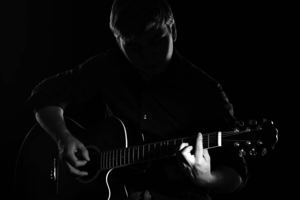Man with guitar in the darkness