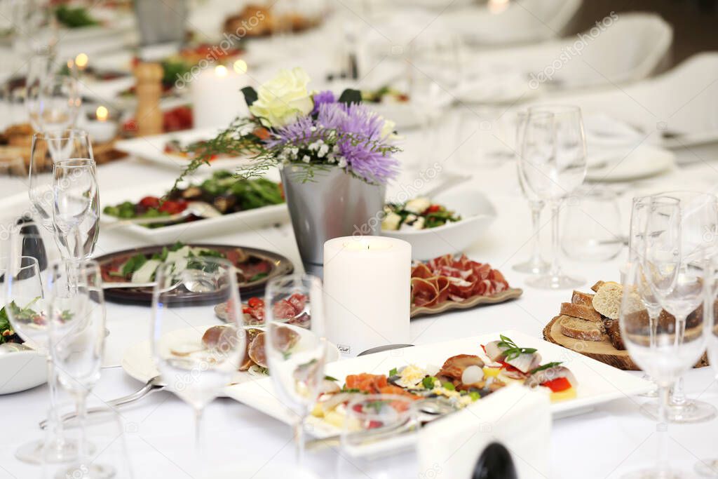 Large dining table with flowers and lots of different kinds of food at a celebration