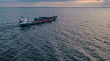 Gün batımında kargo gemisinin deniz manzarası. 