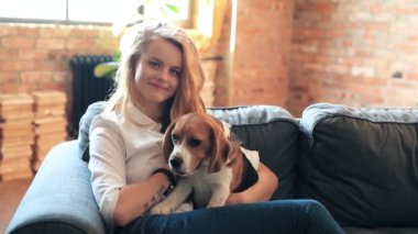 Evde köpekle oynayan güzel genç bir kadın.