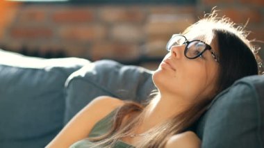 Genç ve güzel bir kadın evde dinleniyor. 