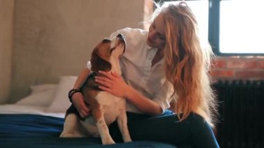 Evde köpekle oynayan güzel genç bir kadın.