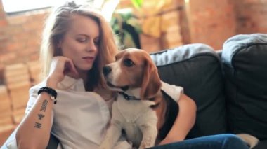 Evde köpekle oynayan güzel genç bir kadın.