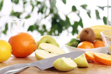 Mutfak masasında farklı taze meyveler var.