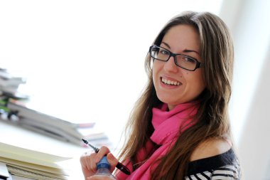 Genç ve güzel kız evde ders çalışıyor.