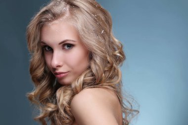 Mavi arka planda kıvırcık saçlı güzel bir kadın.