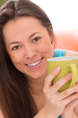 Evinde çay fincanı olan güzel Asyalı kadın.