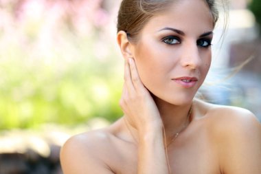 Açık havada poz veren makyajlı güzel bir kızın portresi.