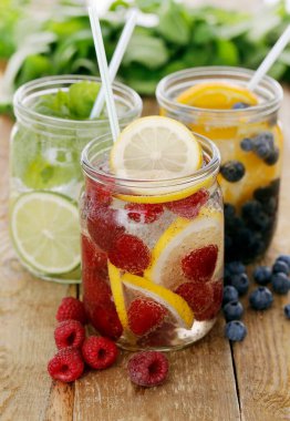 Tahta bir masada pipetle üç farklı soğuk içecek.