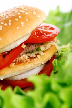 Salata yapraklarının üzerinde büyük ve lezzetli bir burger.