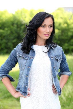 Güzel esmer, bukleli ve makyajlı bir kadın.