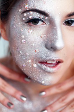 Beyaz bir arka plan üzerinde gümüş beden sanatı ile güzel bir kızın portresi