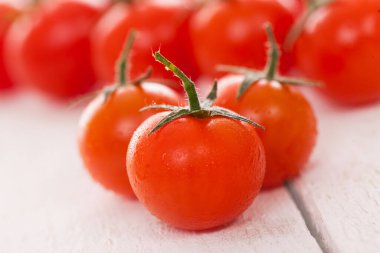 Beyaz ahşap yüzeyde taze kiraz domatesleri. 