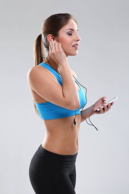 fitness takımındaki güzel beyaz kadın kulaklık takıyor.