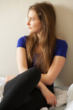 Genç bayan odasında oturuyor. 