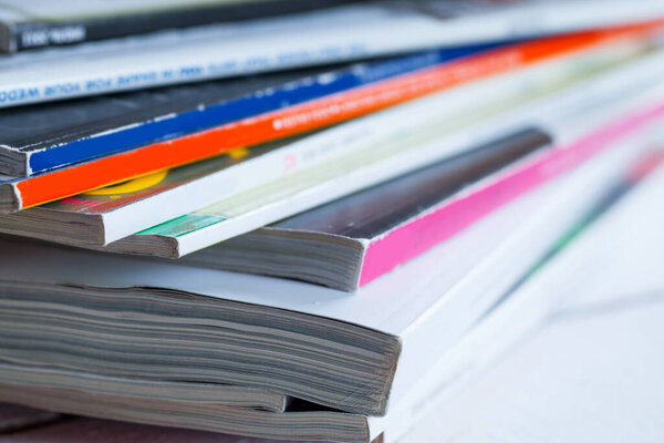 Pile of colorful magazines on a white table