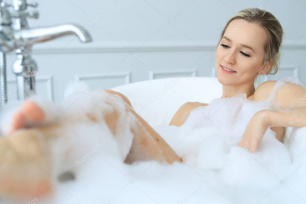 Bathroom. Blond woman in a bathtub