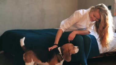 Evde köpekle oynayan güzel genç bir kadın.