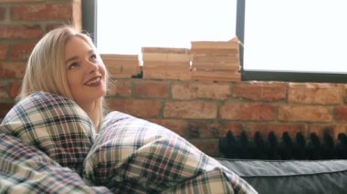 Genç ve güzel bir kadın evde dinleniyor. 