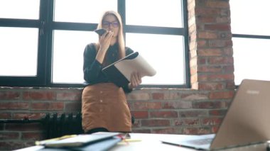 İş kadını ofiste akıllı telefondan konuşuyor.