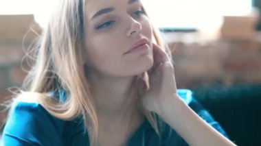 Evdeki yatakta kameraya poz veren bir kadın. 