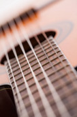 Detailní záběr akustické kytary na hmatníku