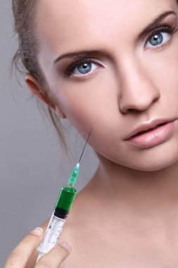 güzel kadın alır iğne onun yüzüne yakın çekim