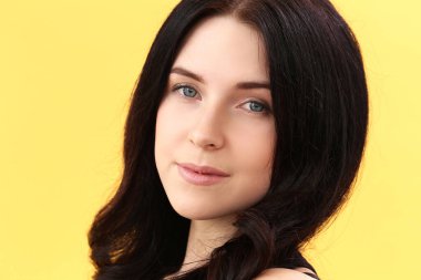 Sarı arka planda poz veren güzel kız.