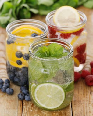 Tahta bir masada pipetle üç farklı soğuk içecek.