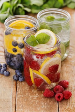 Tahta bir masada pipetle üç farklı soğuk içecek.