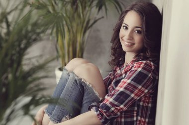 Duvarda oturan tatlı bir kadın.