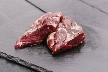 Siyah kesme tahtasındaki taze et.