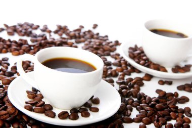 Masada beyaz bardaklı kahve çekirdekleri.