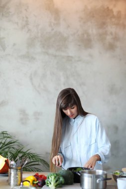 Yemek pişirmek. Kız mutfakta yemek pişiriyor.