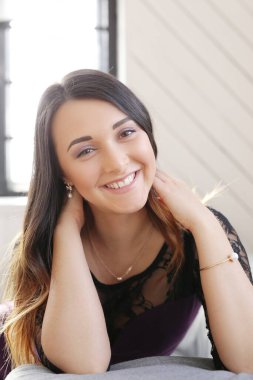 Evde poz veren sevimli esmer kadın.