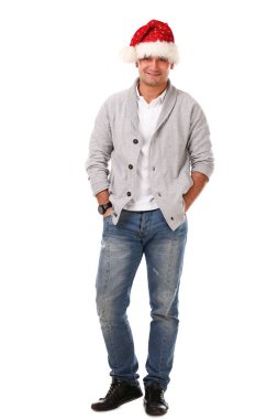 Beyaz arka planda gülümseyen Noel Baba şapkalı genç ve yakışıklı bir adam.