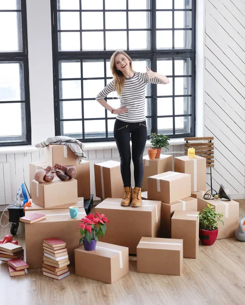 Bir sürü kutuyla yeni eve taşınan hoş bir kadın.